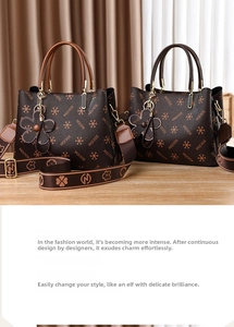 Close-up of brown floral patterned handbags with leather handles and wide fabric straps
