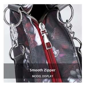 Close-up of smooth metal zipper and cross-grain gothic skull print fabric on tote bag