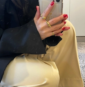 Close-up of minimalist gold geometric rings with cross and open designs worn on fingers