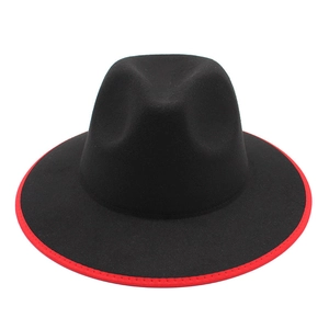 Close-up of a classic black wool fedora featuring a striking red brim edge detail