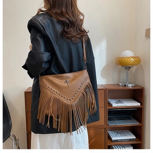 Détail du sac en similicuir marron avec franges bohèmes et rivets métalliques chic
