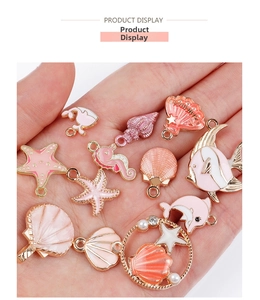 Detailed view of pink enamel ocean charms featuring starfish and dolphin for DIY jewelry