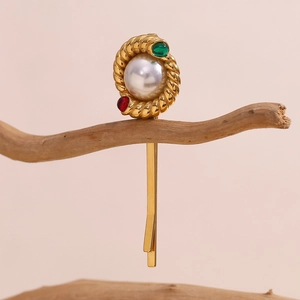 Detail of 18K gold twist hair clip with white pearl and colorful gemstones on a branch
