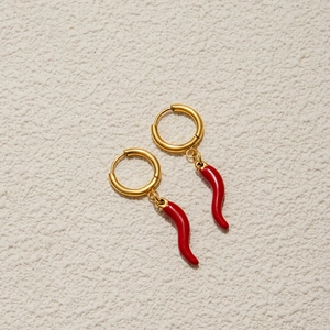 Detailed close-up of golden hoop earrings featuring vibrant red chili pepper pendants