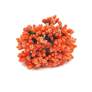 Close-up of bright orange artificial flower stamens and berry clusters for DIY crafts