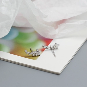 Close-up of curved S925 silver flower stud earrings with sparkling clear cubic zirconia