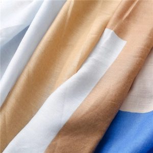 Close-up of woven cotton-linen scarf fabric showing detailed texture and tassels
