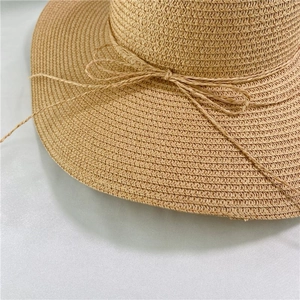 Detail of the woven paper straw sun hat featuring a delicate string bow decoration