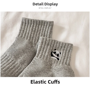 Detail of grey cotton crew socks featuring an elastic cuff and cute panda embroidery