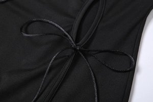 Détail de la robe en résille noire montrant la texture en maille et le laçage