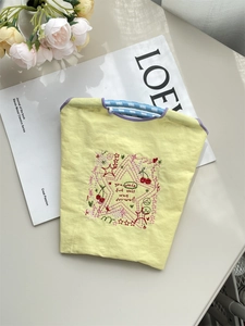 Détail du sac en tissu oxford jaune avec broderie colorée et anse tissée bleue