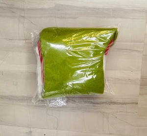 Detail of a festive red and green knitted Christmas stocking in clear packaging