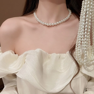 Elegant beaded pearl necklace on model neck with layered white pearl strand details