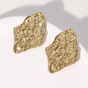 Nahaufnahme der goldenen Edelstahl-Ohrstecker mit unregelmäßiger Hammerschlag-Textur