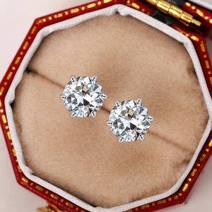 Detailed view of six-prong round cut zircon earrings in a red velvet jewelry box