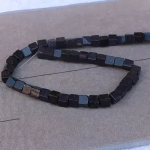 Macro shot of 8mm square blue goldstone beads with glittering stars for DIY jewelry