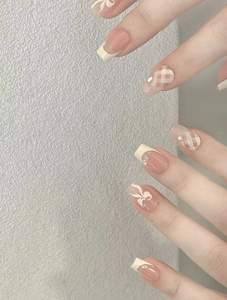 Detail of luxury pink French press-on nails with checkered patterns and small white bows