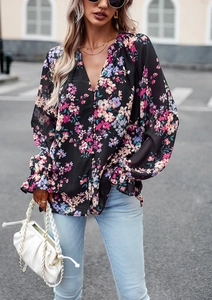 Dettaglio di blusa floreale a maniche lunghe con scollo a V e polsini con volant in città