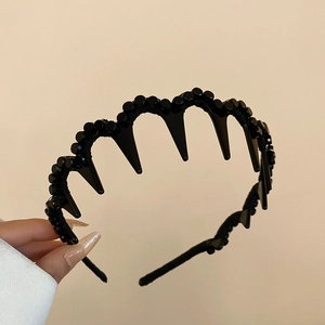 Detail of black wave-shaped non-slip headband with round bead texture and styling teeth