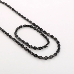 Detailed view of black PVD plated stainless steel anchor chain necklace coiled on white