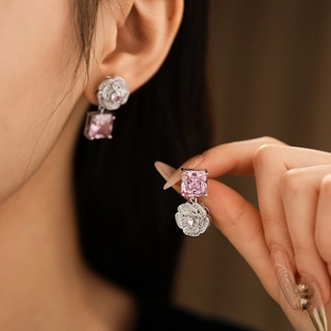Detail of silver earrings with floral pink stone pendant on a model for jewelry set showcase