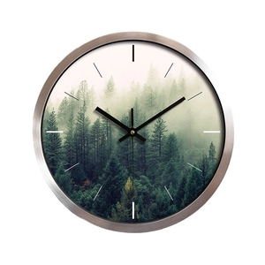 Modern brushed stainless steel wall clock featuring a minimalist forest landscape art dial