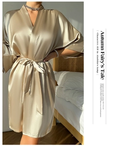 Vue détaillée du peignoir en satin champagne doré avec texture de soie et ceinture nouée
