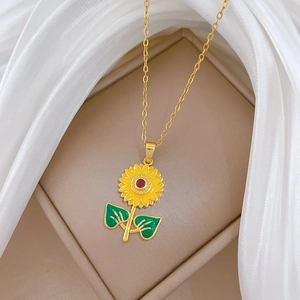 Close-up of luxury sunflower pendant with yellow enamel and red gem in jewelry box