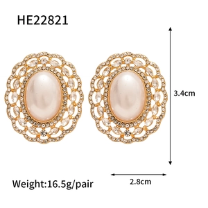 Detailed view of oversized vintage pearl earrings with gold floral trim and crystals