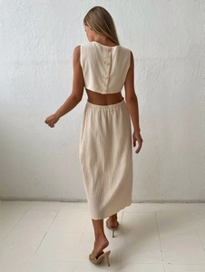 Detail of beige crinkle fabric dress featuring a button-up back and waist cutout design
