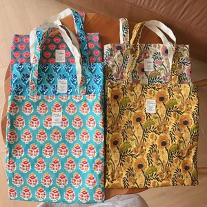 Detailed overhead view of five canvas tote bags with vintage Indian floral prints