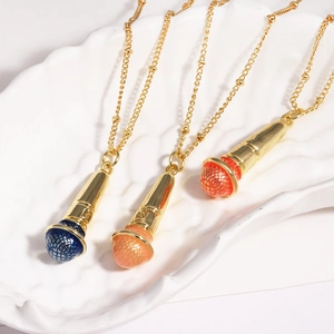 Three microphone necklaces in blue, orange, and red on a white ceramic jewelry tray