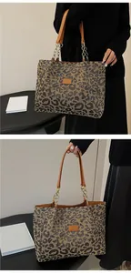 Detail view of leopard print tote bag with brown leather handles and gold chain accents