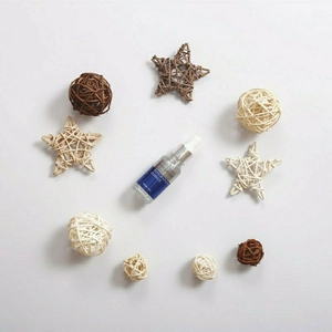 Flat lay of 20ml Hyaluronic Acid Essence bottle surrounded by natural rattan star decor