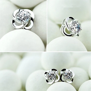 Detailed macro view of silver flower stud earrings with sparkling cubic zirconia stones
