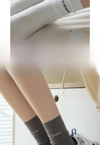 Detail of widened elastic cuff on breathable cotton crew socks with minimalist letters