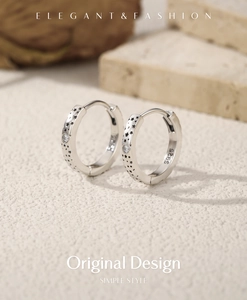 Macro shot of S925 silver hoop earrings featuring matte finish and black star details