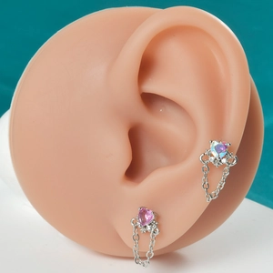 Détails de boucles d'oreilles cœur rose et holographique avec pampilles sur modèle en silicone