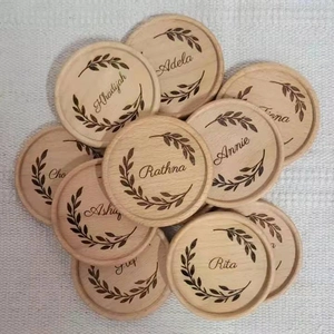 Macro detail of custom engraved wooden coasters with personalized names and leaf patterns