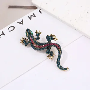 Vintage lizard brooch with blue and magenta rhinestones on antique gold alloy base