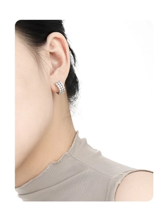 Detailed view of silver honeycomb hoop earring with zircon micro-pave on model ear