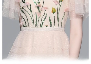 Detail of pink mesh dress featuring floral embroidery, sequins and lace waist