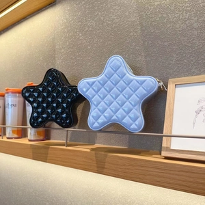 Close-up of star-shaped quilted handbags in black and light blue on a shelf