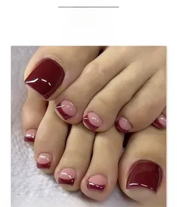 Detail of short square press-on toenails featuring burgundy and nude geometric French design