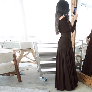 Detail of dark brown off-shoulder dress with pleated texture and slim fit silhouette