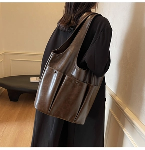 Detailed view of the multi-pocket design on this vintage dark brown leather tote bag