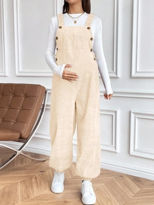 Detail of apricot corduroy maternity overalls with adjustable waist and ribbed texture