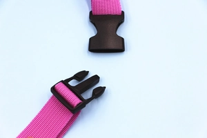 Detail of pink nylon shoulder strap with a durable black plastic side-release buckle