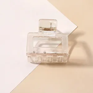 Close-up of a clear rectangular claw clip with a hollow design and metallic spring