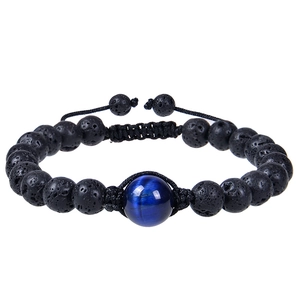 Dettaglio del bracciale intrecciato regolabile con pietre laviche nere e occhio di tigre blu